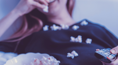 Woman-watching-TV_eating-popcorn-and-holding-remote-1200×480-1.png